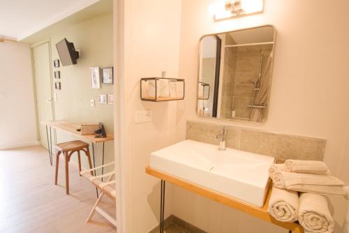 a bathroom with a white sink and a mirror at La Belle lurette in Bressuire
