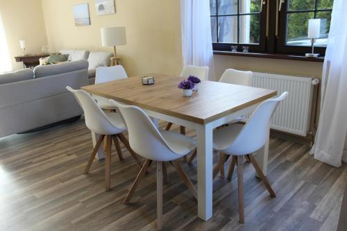 uma mesa de jantar e cadeiras numa sala de estar em Steens Huus em Grossenbrode