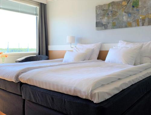 a large bed in a bedroom with a window at Park Hotel Tornio in Tornio
