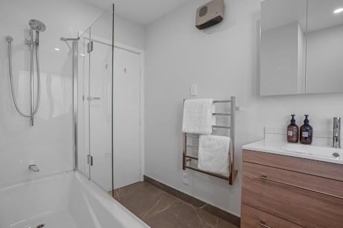a white bathroom with a shower and a sink at Private Family 4BR Home, Near Airport, Free Parking in Christchurch