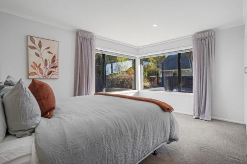 a bedroom with a bed and a large window at Private Family 4BR Home, Near Airport, Free Parking in Christchurch