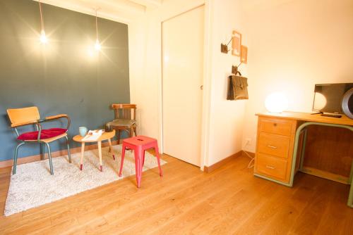 a room with chairs and a table and a tv at La Belle lurette in Bressuire