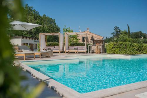 una piscina con sillas y una casa en Villa Sky 14, en Massa Fermana