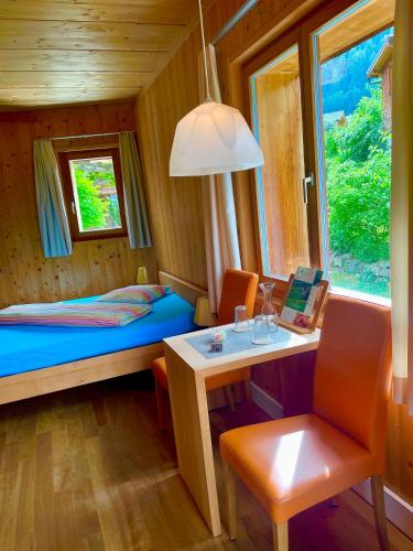 a small room with a bed and a desk and a window at BerglandHof Hotel Ernen in Ernen