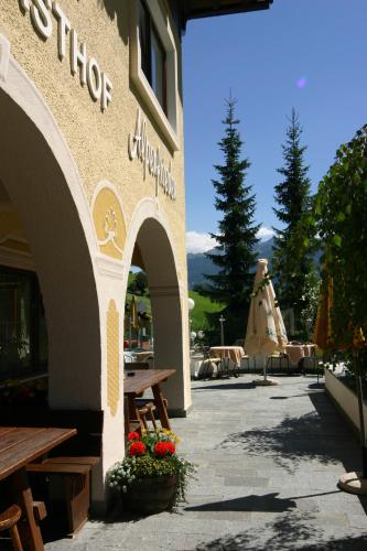 a building with a table and benches and a patio at Hotel Alpenfrieden in Rio Bianco