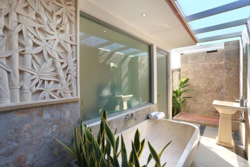 a bathroom with a large window and a bath tub at ECHO BEACH DESIGNER APARTMENT in Canggu
