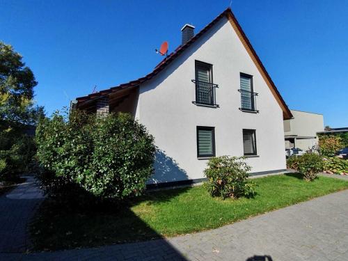 une maison blanche avec deux fenêtres et une cour dans l'établissement Ferienhaus Spreedeich, à Werben