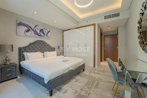 a bedroom with a bed and a desk and a chair at KeyHost - Large 1BR Apartment near Five Hotel JVC - Dubai - K310 in Dubai