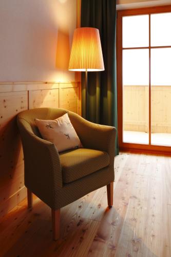 a living room with a chair and a lamp at Hotel Alpenfrieden in Rio Bianco