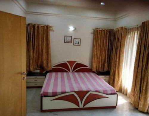 a bedroom with a bed with a pink and white cover at StayApart - The Himalayan Stay in Gopeshwar