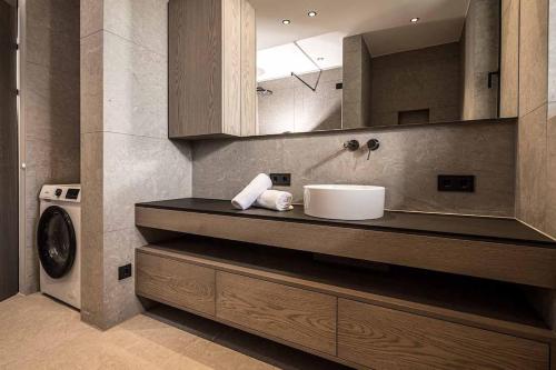 a bathroom with a sink and a washing machine at Panorama Nature Lodge in Hart im Zillertal