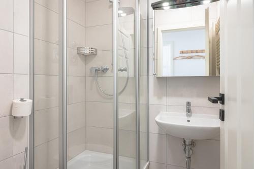 uma casa de banho com um chuveiro e um lavatório. em JOHOUSE Apartment 9 em Warnemünde