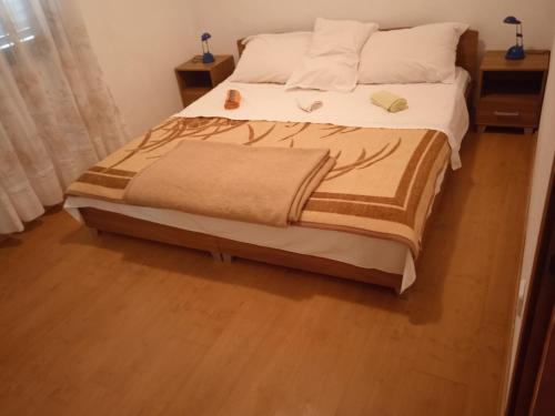 Un dormitorio con una cama grande con suelo de madera. en Apartments MARE, en Ždrelac