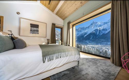 a bedroom with a large window with a mountain view at Le Chalet Mont Blanc in Les Houches