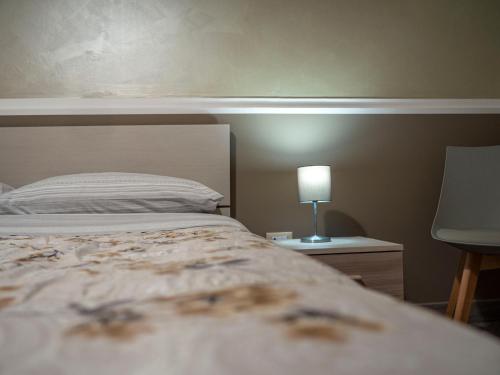 a bedroom with a bed and a lamp on a table at Villa Paestum in Paestum