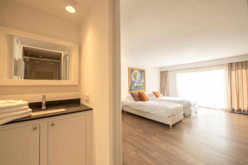 a bathroom with a bedroom with a bed and a sink at Guesthouse Brouwershuis in Poperinge
