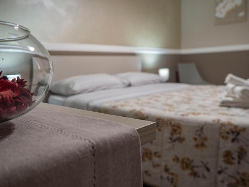 a room with two beds and a bowl of flowers on a table at Villa Paestum in Paestum