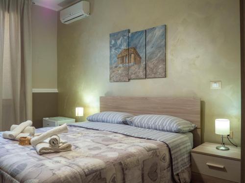 a bedroom with a bed and a painting on the wall at Affittacamere Villa Paestum in Paestum