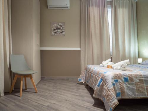a bedroom with a bed and a chair and a window at Villa Paestum in Paestum
