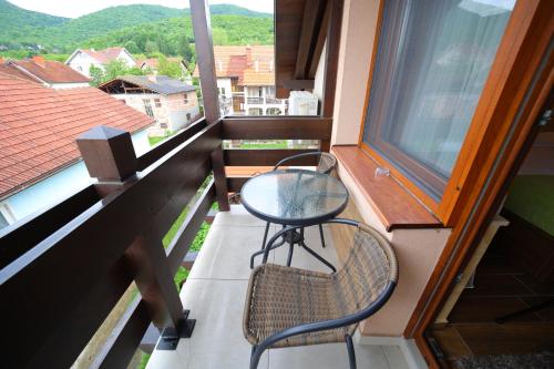 a balcony with two chairs and a table and a window at Vila Almax in Soko Banja
