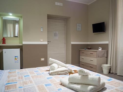 a bedroom with a bed with towels on it at Villa Paestum in Paestum