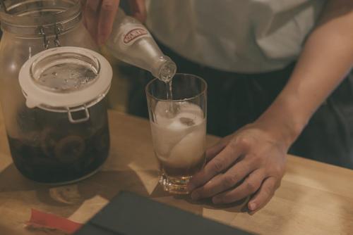 a person is pouring a drink into a glass at Nari Nuttari Nari in Niigata