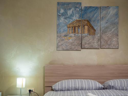 a bedroom with a bed and a painting on the wall at Villa Paestum in Paestum