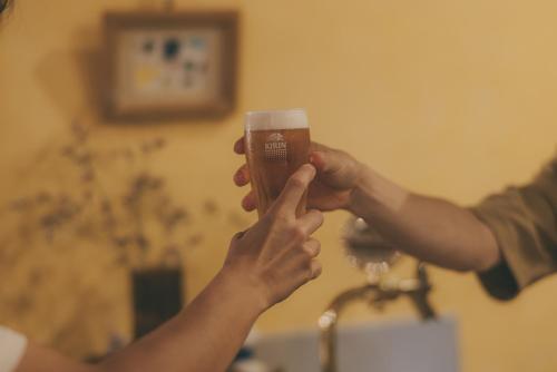 two people holding hands while holding a cup of coffee at Nari Nuttari Nari in Niigata