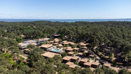 - une vue aérienne sur un complexe avec des arbres et de l'eau dans l'établissement Domaine du Ferret Restaurant & Spa, à Cap-Ferret