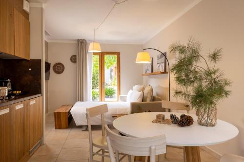 a kitchen and living room with a table and a bed at Domaine du Ferret Restaurant & Spa in Cap-Ferret