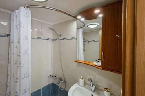 een badkamer met een douchegordijn en een wastafel bij Oasis Home Heraklion in Heraklion