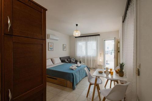 een slaapkamer met een bed en een tafel en stoelen bij Oasis Home Heraklion in Heraklion