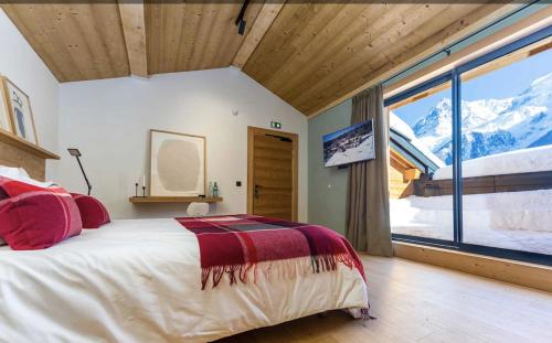 a bedroom with a bed and a large window at Le Chalet Mont Blanc in Les Houches