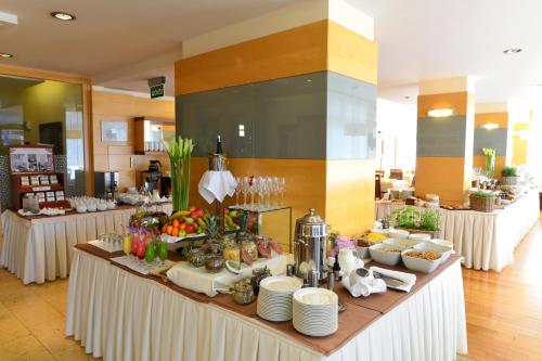 a buffet line with white tables with food on them at Hotel Lovec in Bled