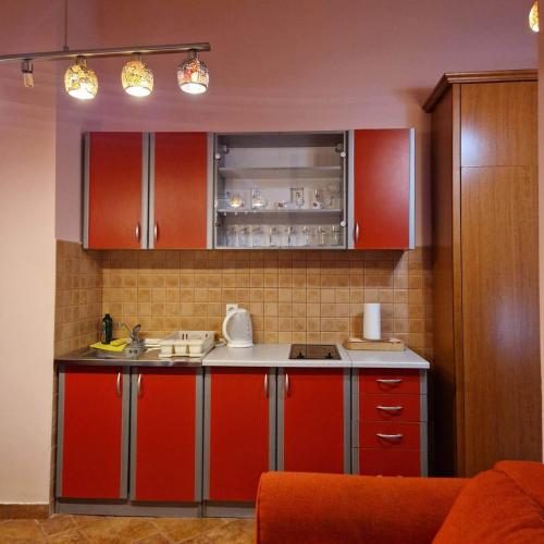 a kitchen with red cabinets and a counter top at Apartments Ivetić in Kotor
