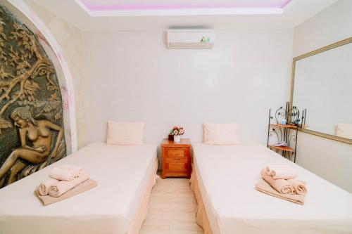 two beds in a room with towels on them at A25 Luxury Hotel in Hanoi