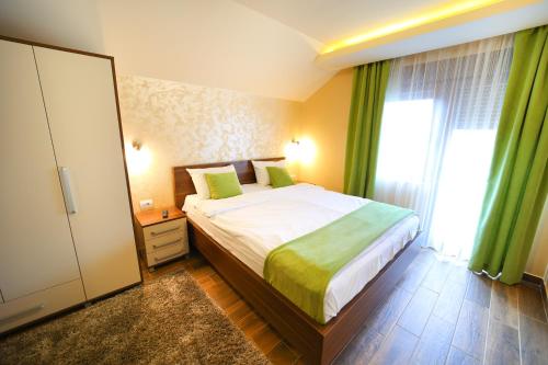 a bedroom with a bed and a large window at Vila Almax in Soko Banja