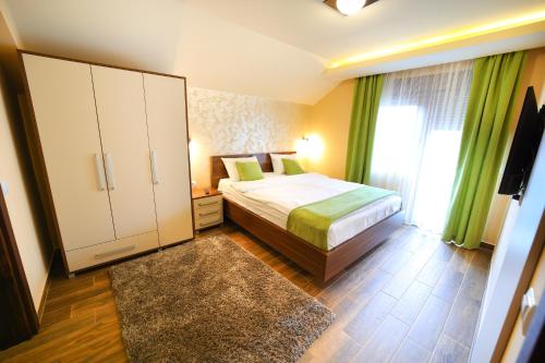 a bedroom with a bed and a cabinet and a window at Vila Almax in Soko Banja