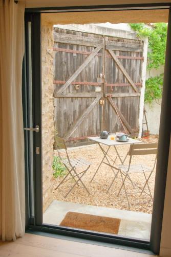 a sliding glass door with a table and a fence at La Belle lurette in Bressuire