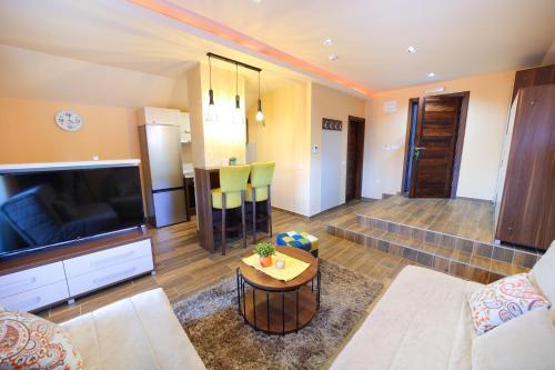 a living room with a large television and a table at Vila Almax in Soko Banja