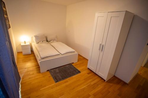 Modern Innsbruck Apartment I Free Parking في إنسبروك: غرفة نوم صغيرة بها سرير وخزانة