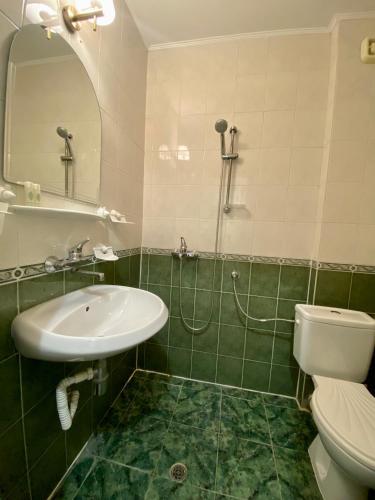 a bathroom with a sink and a toilet and a mirror at Wild Cherry Apartments in Saints Constantine and Helena