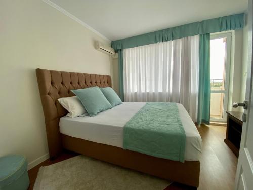 1 dormitorio con 1 cama y ventana grande en Wild Cherry Apartments, en Saints Constantine and Helena