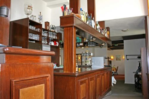 a bar with a wooden counter in a room at Hotel Pelli Hof Rendsburg by Tulip Inn in Rendsburg