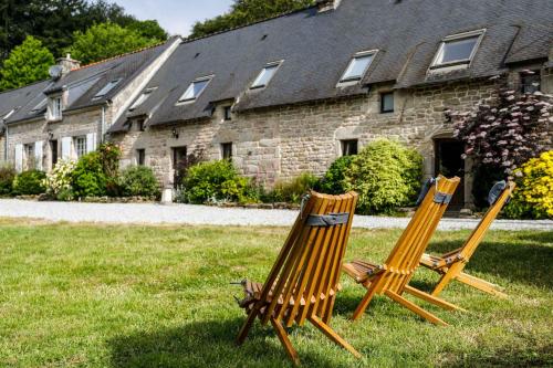 two chairs sitting in the grass in front of a house at FORET TOTEM - Hébergements nature et bien-être en pleine forêt in Persquen