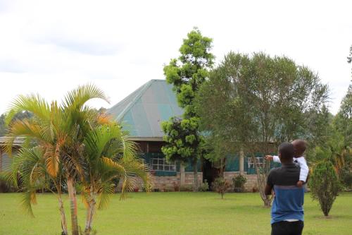 a couple of people standing in front of a house at Muga Eco Village in Ntungamo