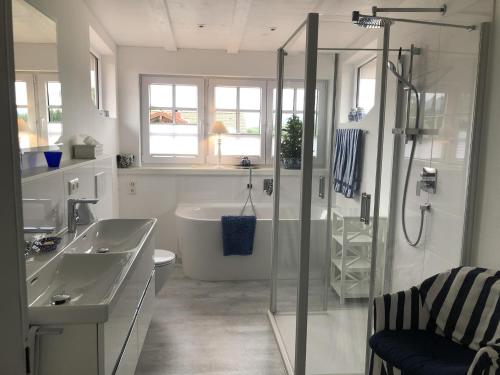 een badkamer met een douche, een wastafel en een bad bij Ferienwohnung Häusler in Fischen