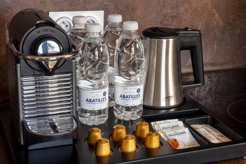 un mostrador con botellas de agua y una licuadora en Domaine du Ferret Restaurant & Spa, en Cap-Ferret