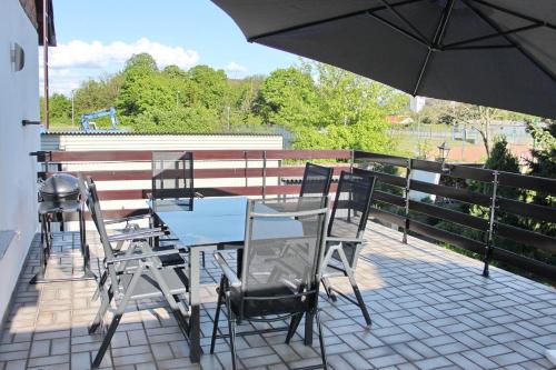 a table and chairs on a balcony with an umbrella at Ferienwohnung Spreemitte in Lübbenau