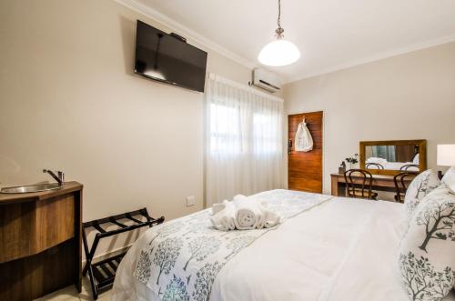 a bedroom with a bed with a towel on it at Three Olives Guesthouse in Centurion